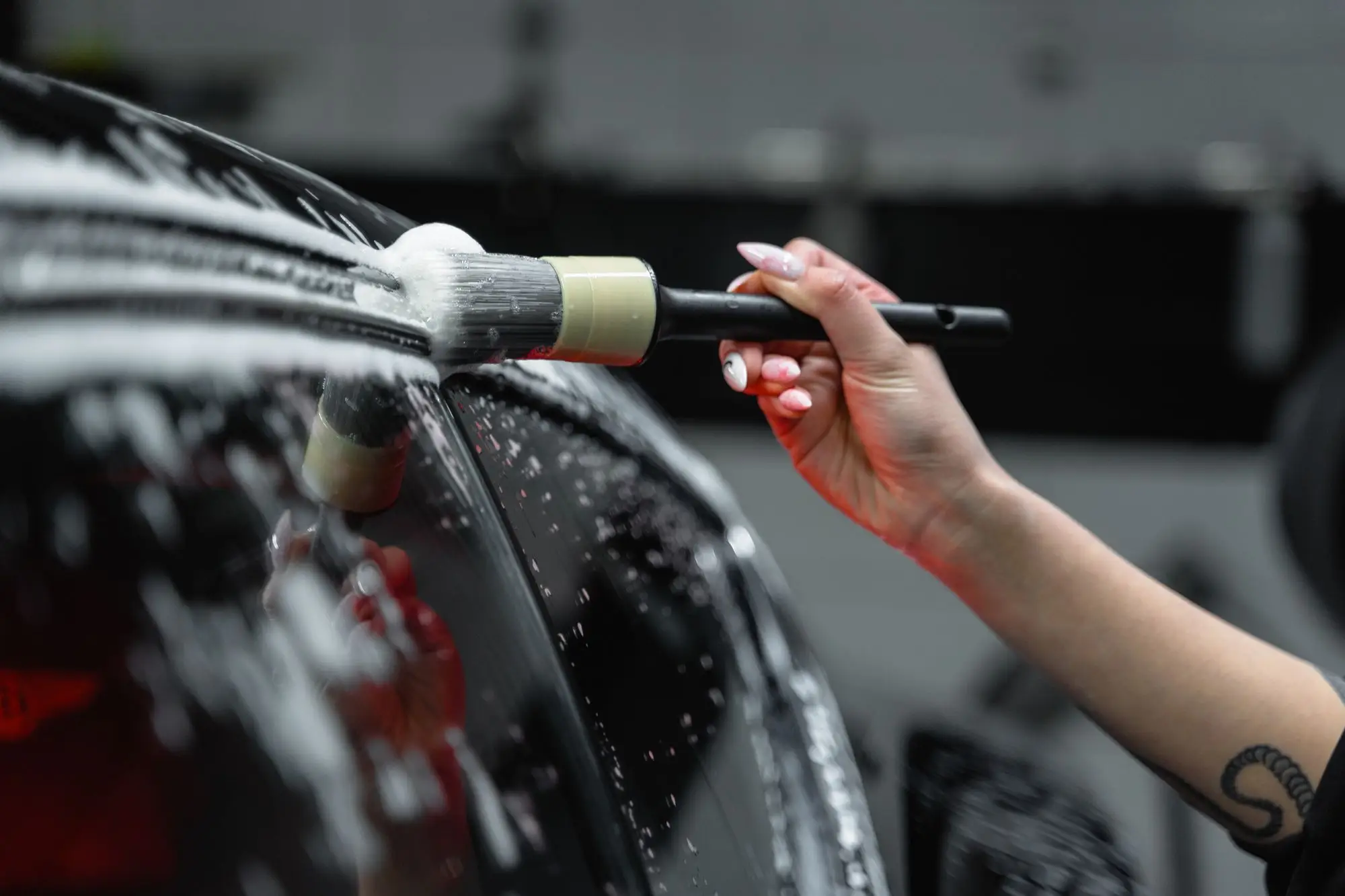 Bodi mobil disabun dengan kuas detailing saat proses cuci